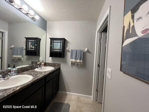 1015 Swiss Pointe Lane Rockledge, FL 32955 - Photo 22 of 26 a bathroom with a granite countertop sink a mirror and a shower