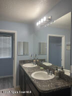 1015 Swiss Pointe Lane Rockledge, FL 32955 - Photo 26 of 26 a bathroom with a granite countertop sink a mirror and a vanity