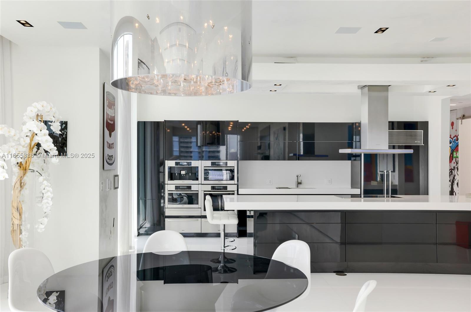 900 Brickell Key Boulevard, Unit 2603 Miami, FL 33131 - Photo 25 of 99 a kitchen with a table chairs and a living room view