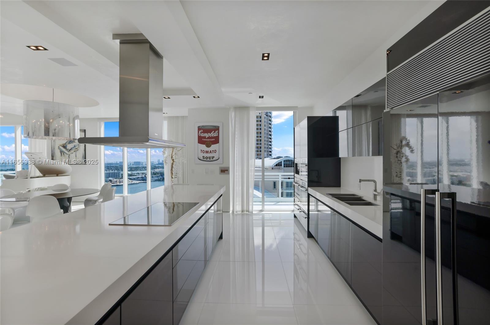 900 Brickell Key Boulevard, Unit 2603 Miami, FL 33131 - Photo 31 of 99 a large kitchen with kitchen island a large counter top stainless steel appliances and a large window