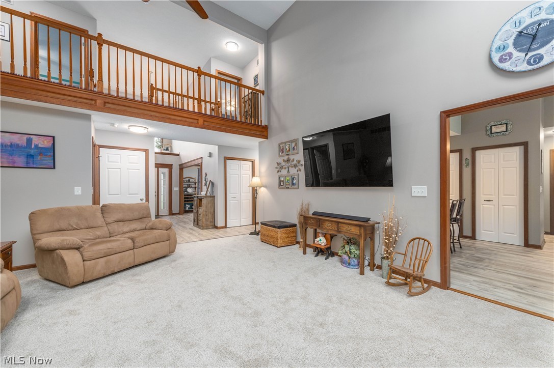 44565 Stang Road Elyria, OH 44035 - Photo 18 of 50 Living room with vaulted cathedral ceiling, dual Skylights, a brick fireplace, carpet floors, and plenty of natural woodwork and light.