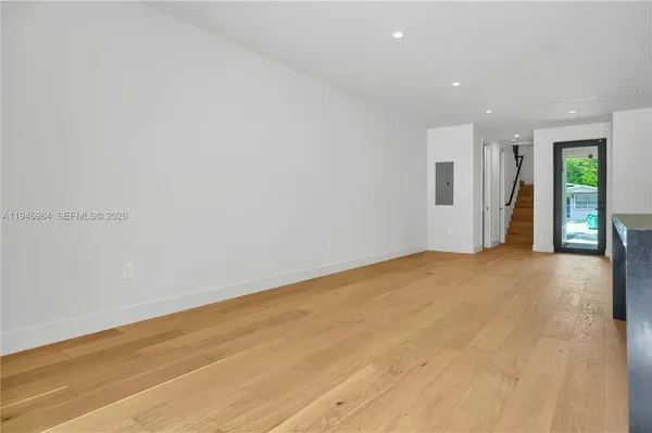 a view of an empty room with wooden floor