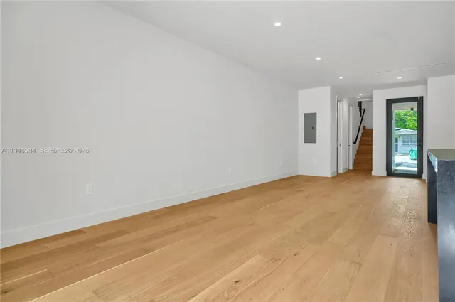 a view of an empty room with wooden floor