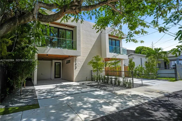 a front view of a house with a tree