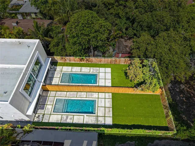 an aerial view of a swimming pool with a yard