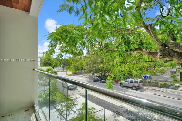 a view of an empty room with wooden floor and closet