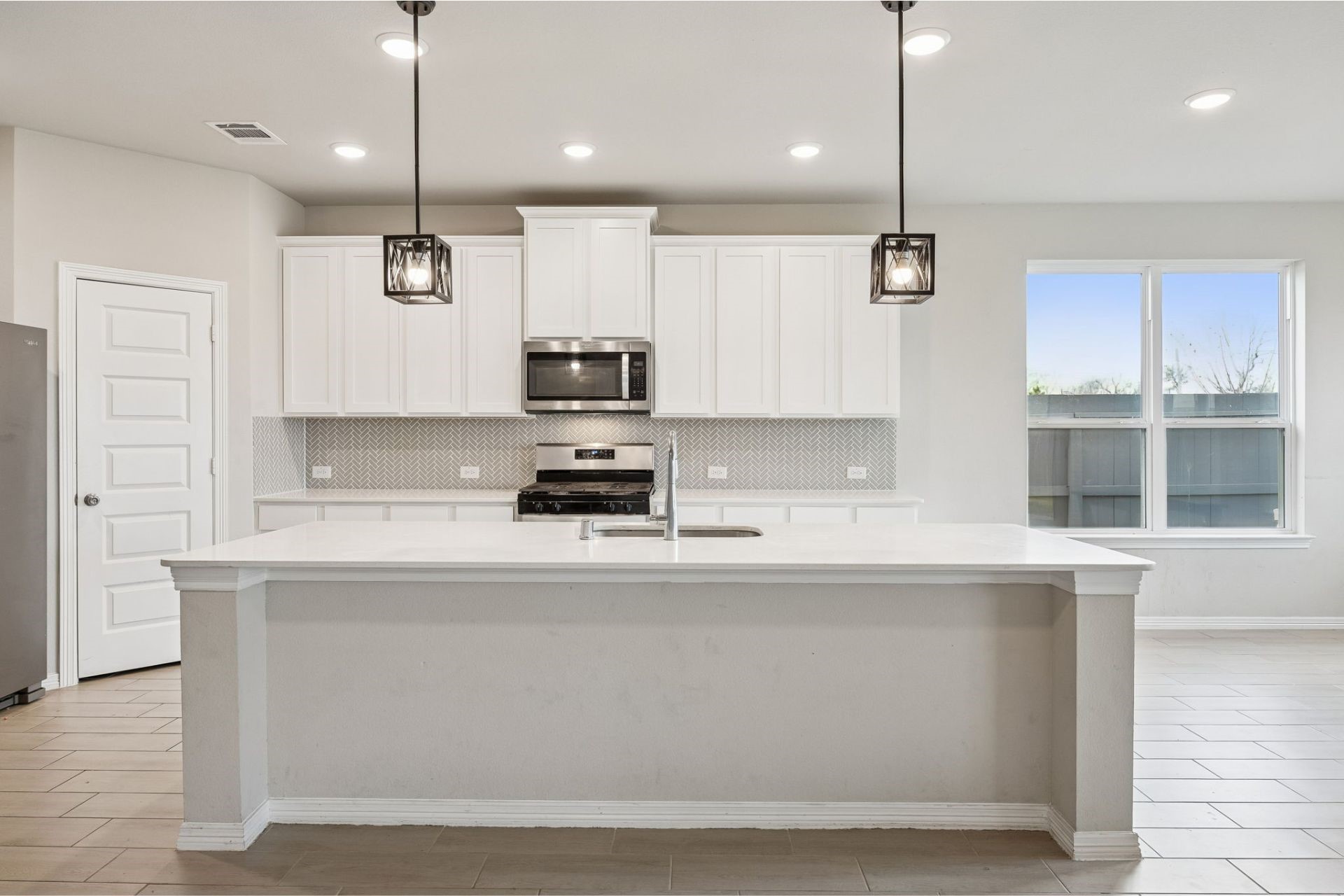 8103 Red Shiner Way Fulshear, TX 77441 - Photo 10 of 29 a kitchen with kitchen island stainless steel appliances a sink a counter and cabinets