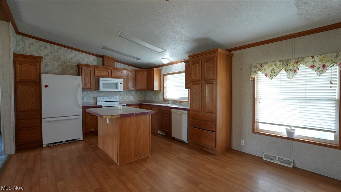 59062 Marietta Road Byesville, OH 43723 - Photo 6 of 33 Kitchen with lofted ceiling, white appliances, light wood-type flooring, a center island, and ornamental molding
