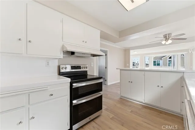 a kitchen with white cabinets and appliances