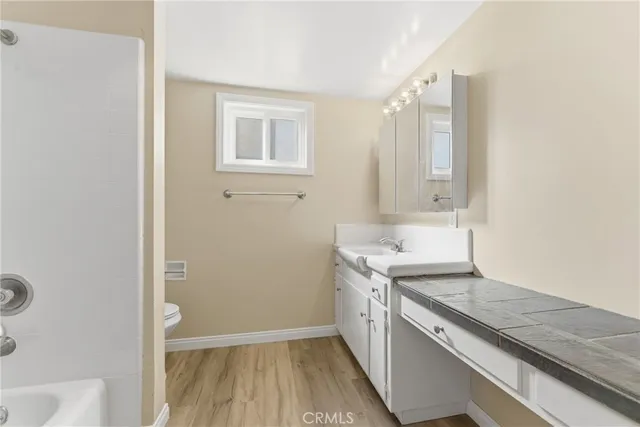 a view of a kitchen with wooden floor and electronic appliances