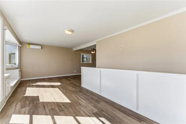 a view of a room with wooden floor and white walls