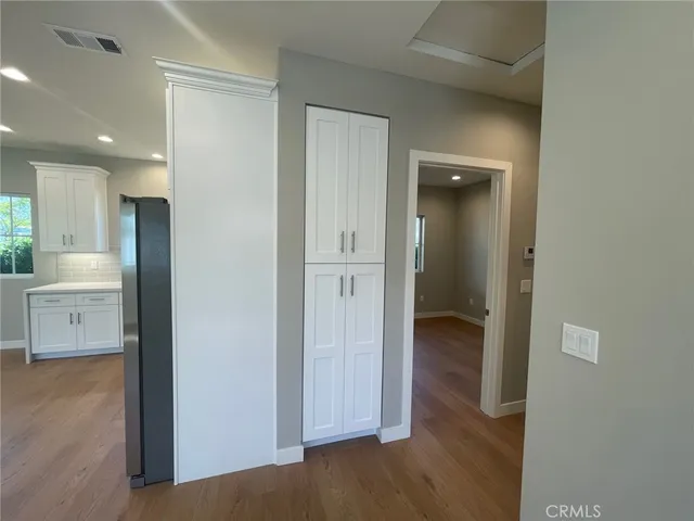 an empty room with wooden floor and a sink
