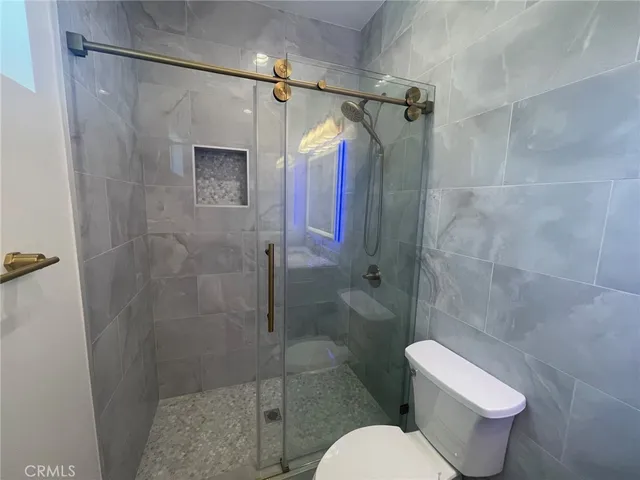 a bathroom with a toilet and a shower