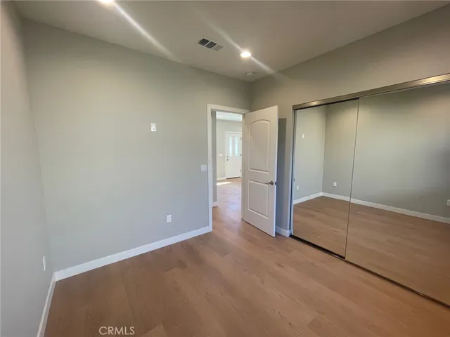 an empty room with closet and wooden door