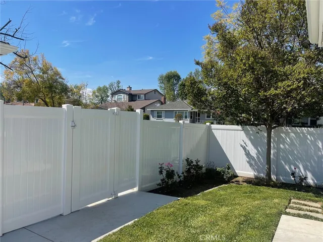 a view of a house with backyard and a tree