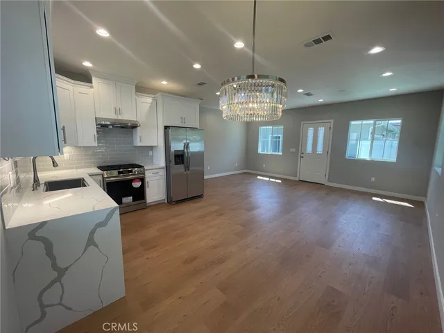 a view of a kitchen with refrigerator and windows