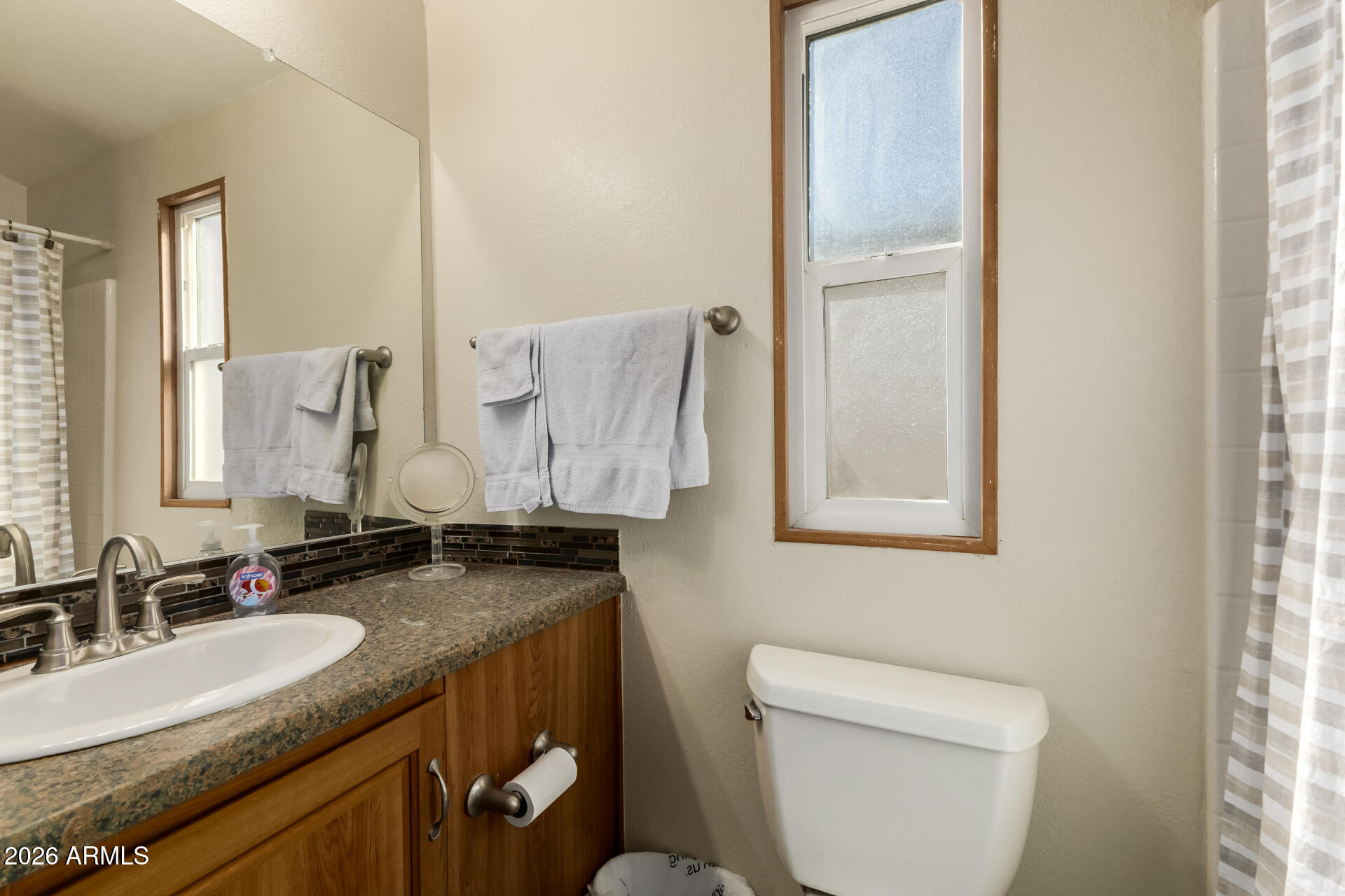 111 South Greenfield Road, Unit 104 Mesa, AZ 85206 - Photo 26 of 74 a bathroom with a granite countertop sink toilet and mirror