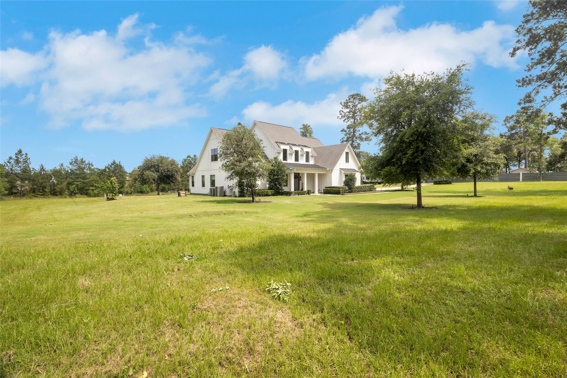 40498 Community Road Magnolia, TX 77354 - Photo 29 of 32 a view of an ocean with large trees and buildings in the background