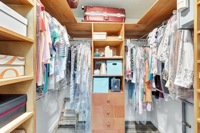 a view of walk in closet with clothes and shoes
