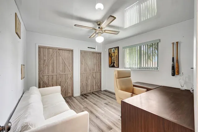 a view of a workspace with furniture and a window