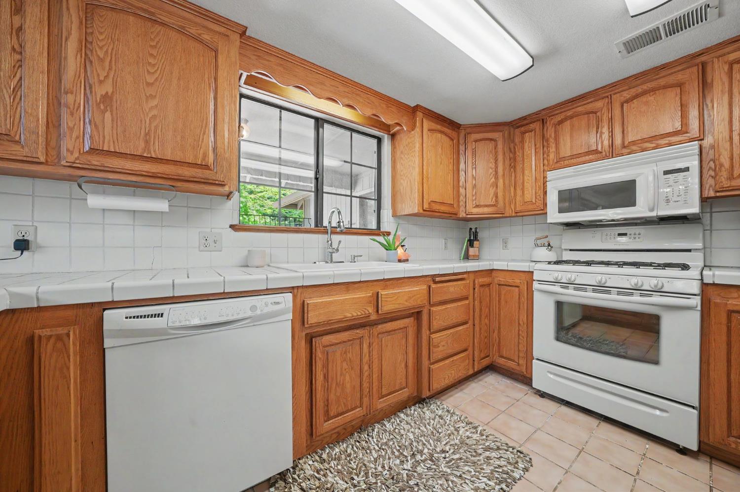 20310 State Rte 26 West Point, CA 95255 - Photo 17 of 57 a kitchen with granite countertop a sink cabinets stainless steel appliances and a window