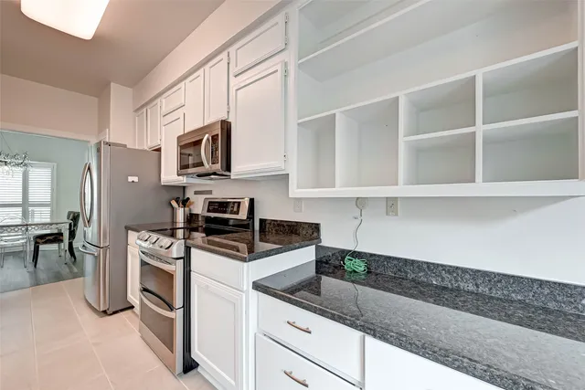a kitchen with stainless steel appliances granite countertop a sink and a stove