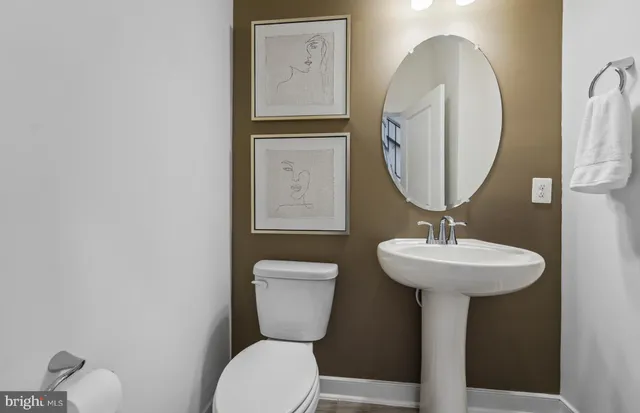 a bathroom with a toilet a sink and mirror