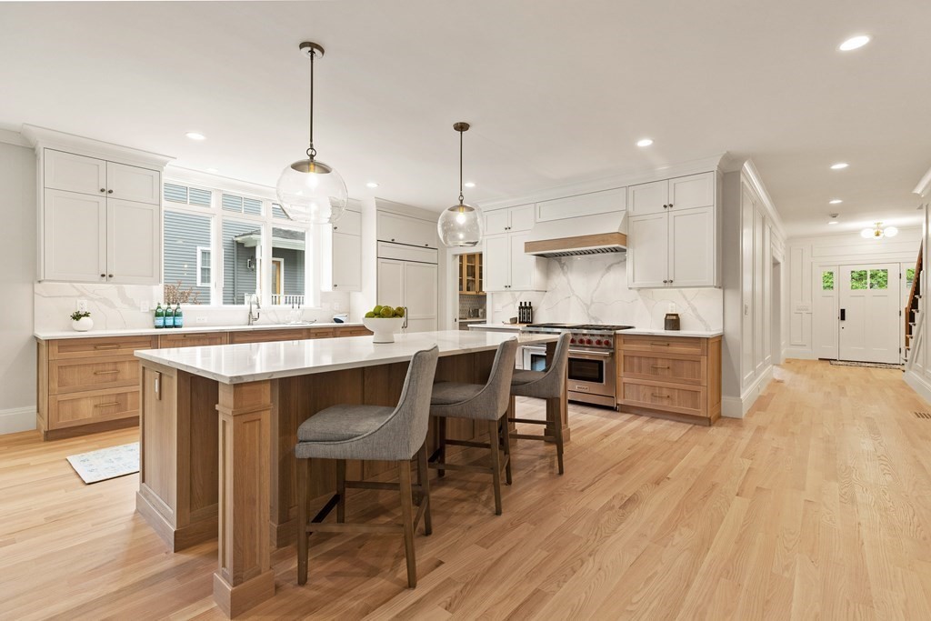 11 Sherman Street Lexington, MA 02420 - Photo 13 of 40 a kitchen with a sink stove and white cabinets with wooden floor