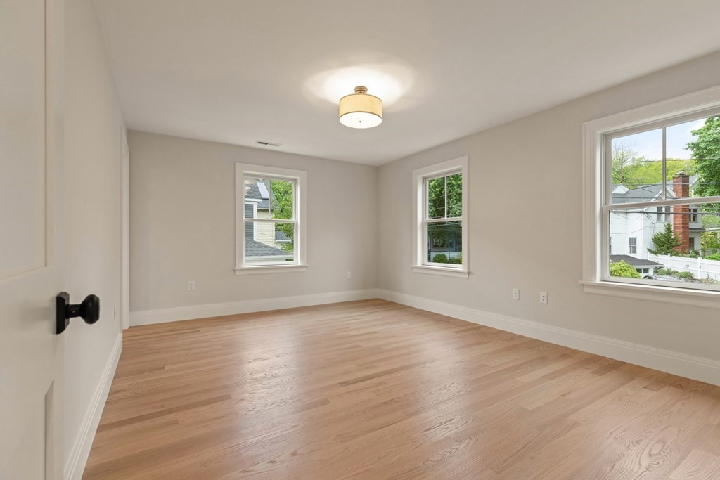 11 Sherman Street Lexington, MA 02420 - Photo 29 of 40 a view of an empty room with a window and wooden floor
