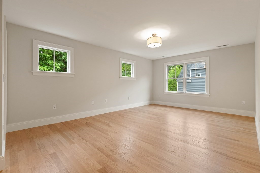 11 Sherman Street Lexington, MA 02420 - Photo 32 of 40 a view of an empty room with a window and wooden floor