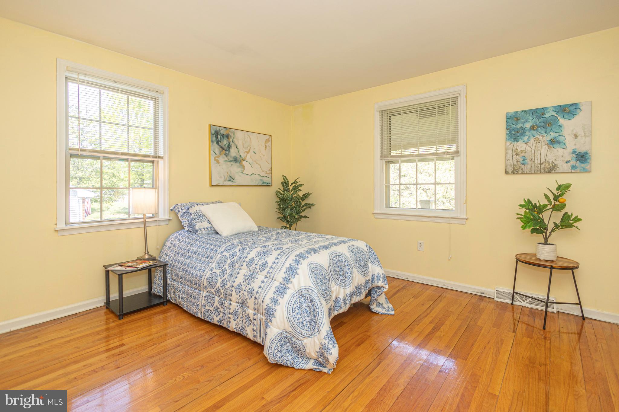 2316 Shipley Road Wilmington, DE 19803 - Photo 25 of 42 a spacious bedroom with a bed windows and a wooden floor