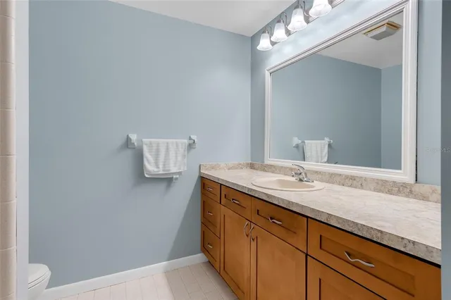 a bathroom with a granite countertop sink a toilet and a mirror