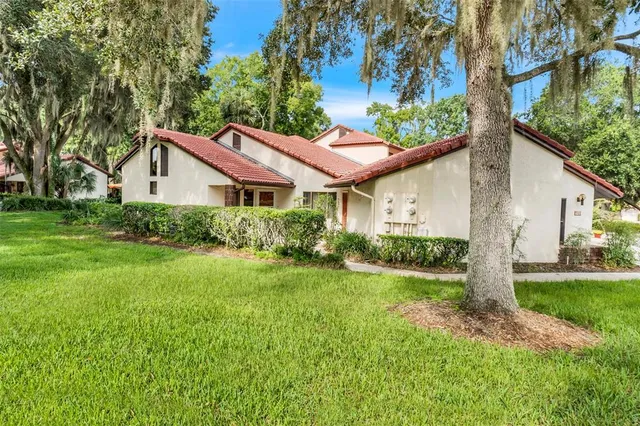 a front view of a house with a yard and trees