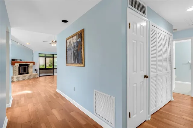 a view of a hallway with wooden floor and a kitchen