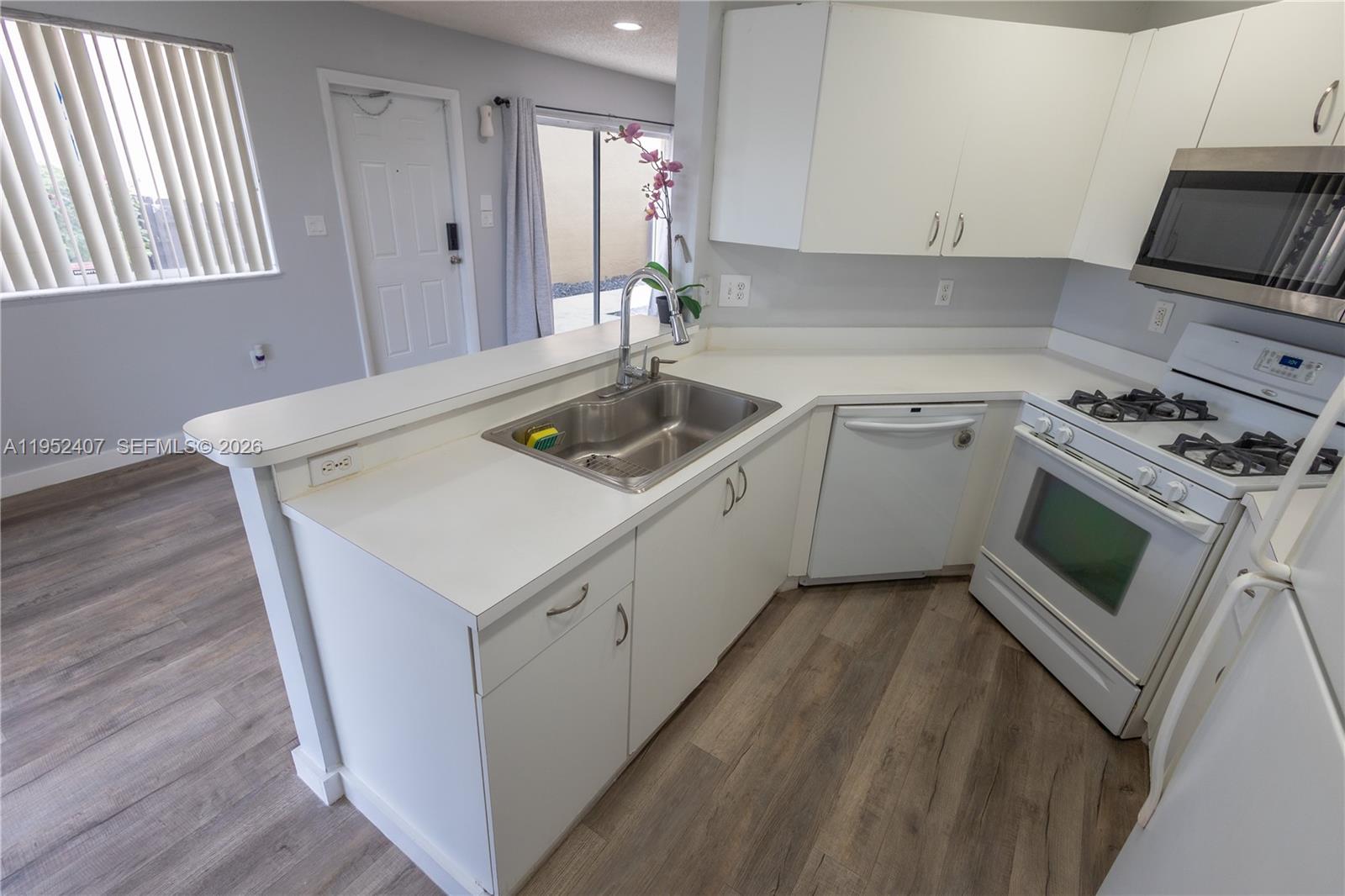 16831 Southwest 139th Place Miami, FL 33177 - Photo 13 of 39 a kitchen with a sink stove and cabinets