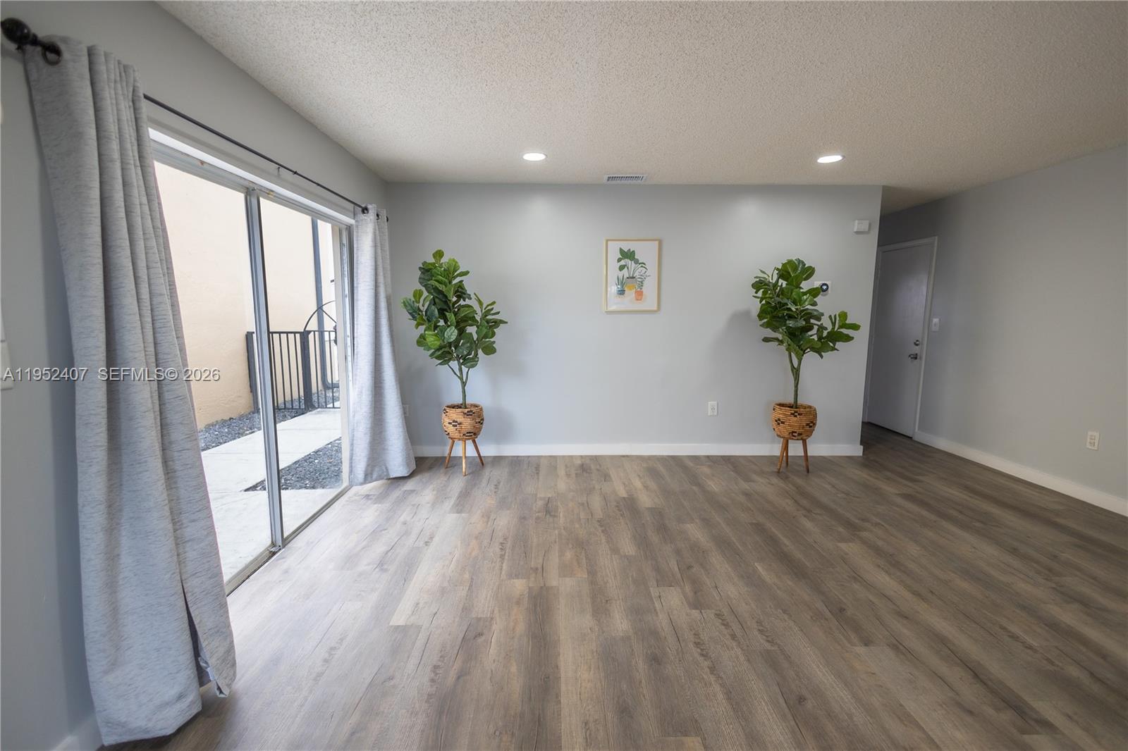 16831 Southwest 139th Place Miami, FL 33177 - Photo 7 of 39 a view of empty room with wooden floor and potted plant