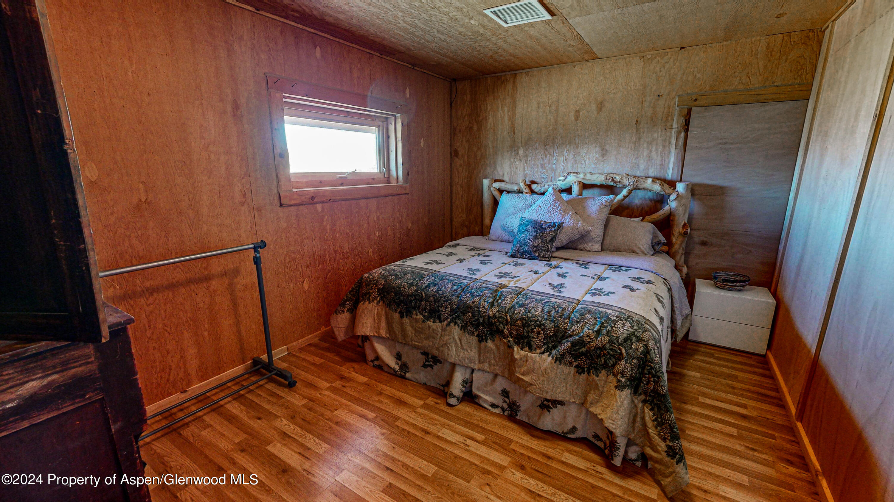 56106 Me Road Collbran, CO 81624 - Photo 31 of 34 a bedroom with a bed and wooden floor