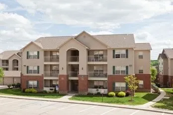 a front view of a residential apartment building with a yard and garage