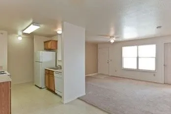 an empty room with windows and refrigerator