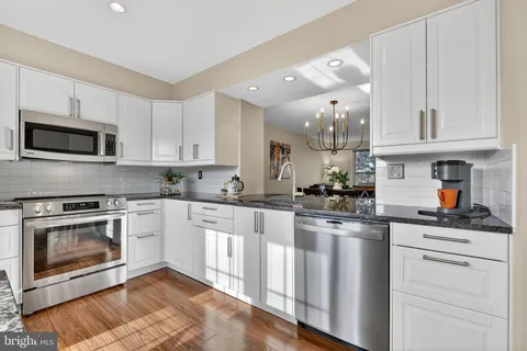 a kitchen with granite countertop a stove top oven and cabinets