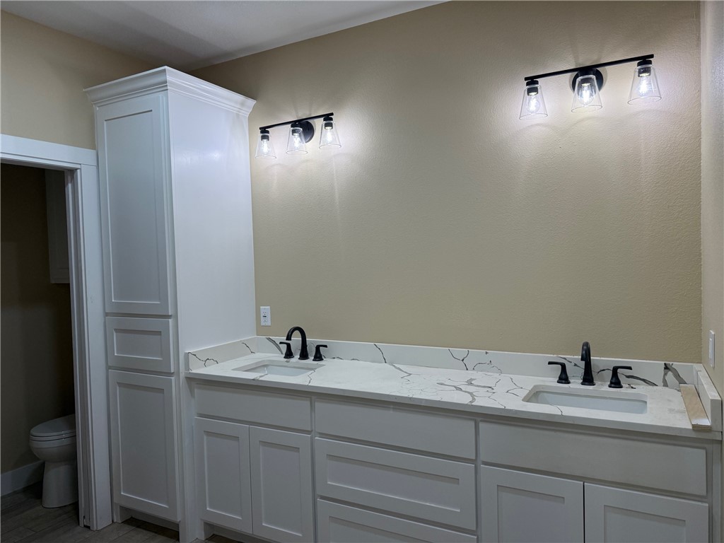 807 South Coulter Drive Bryan, TX 77803 - Photo 10 of 17 a bathroom with a double vanity sink toilet and a mirror