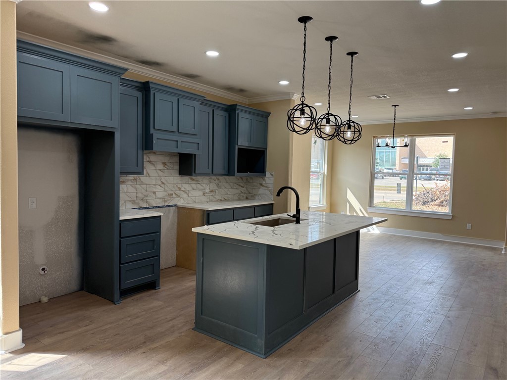 807 South Coulter Drive Bryan, TX 77803 - Photo 5 of 17 a kitchen with stainless steel appliances granite countertop a sink a stove and a wooden floors