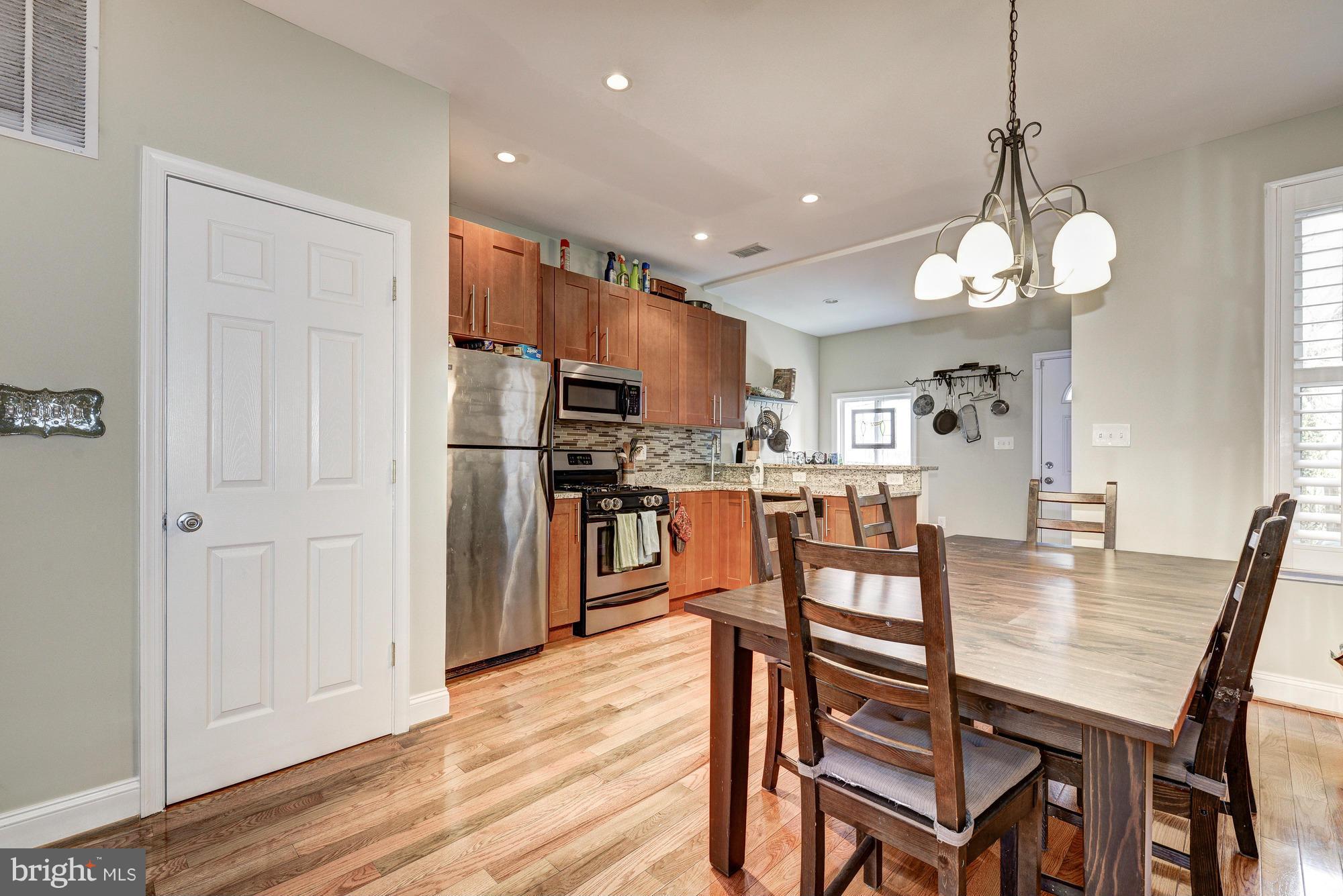 2017 2nd Street Northeast Washington, DC 20002 - Photo 8 of 23 a kitchen with stainless steel appliances granite countertop a dining table chairs refrigerator and cabinets