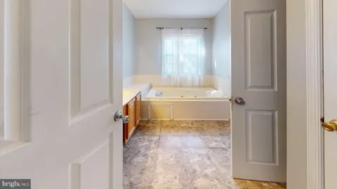 a bathroom with a bathtub sink and mirror
