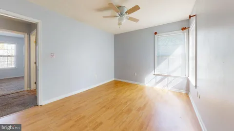 a view of a big room with wooden floor and windows