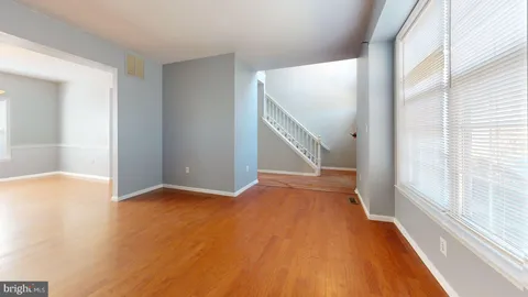a view of an empty room with wooden floor