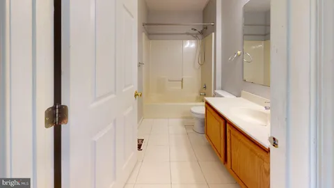 a bathroom with a double vanity sink a toilet and shower