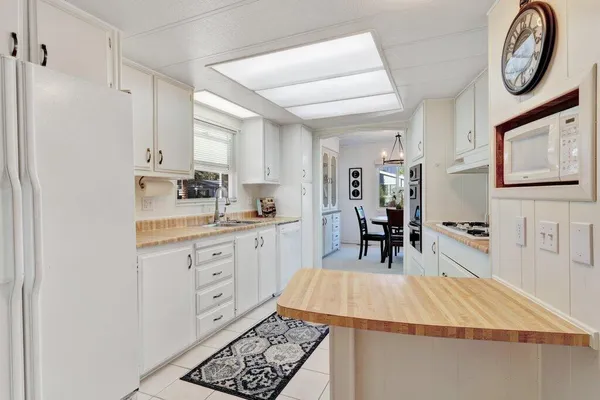 a kitchen with white cabinets and appliances