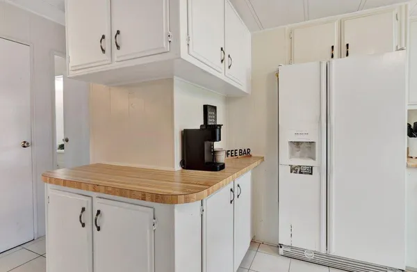 a very nice looking kitchen with granite countertop a sink a stove a dining table and chairs