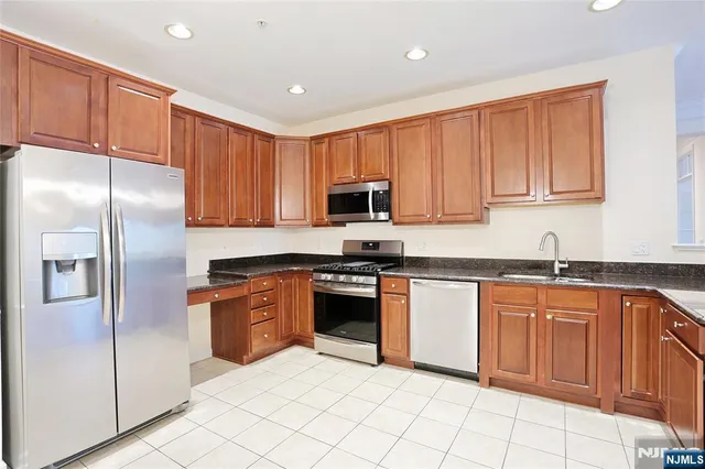 a kitchen with stainless steel appliances granite countertop a refrigerator sink and cabinets